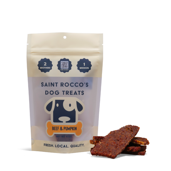 A bag of Beef and Pumpkin dog treats is shown with several rectangular, all-natural treats beside it. The packaging features a cartoon dog and the text "Fresh. Local. Quality."—perfect for training your pup.