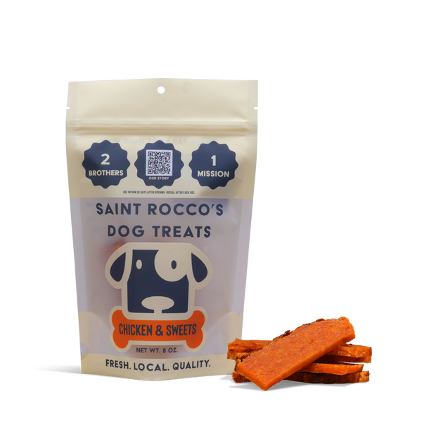 A beige resealable bag labeled “Chicken and Sweets” stands upright beside several orange dog treats. The bag features a cartoon dog face and includes text highlighting quality, ingredients, and training treat benefits.