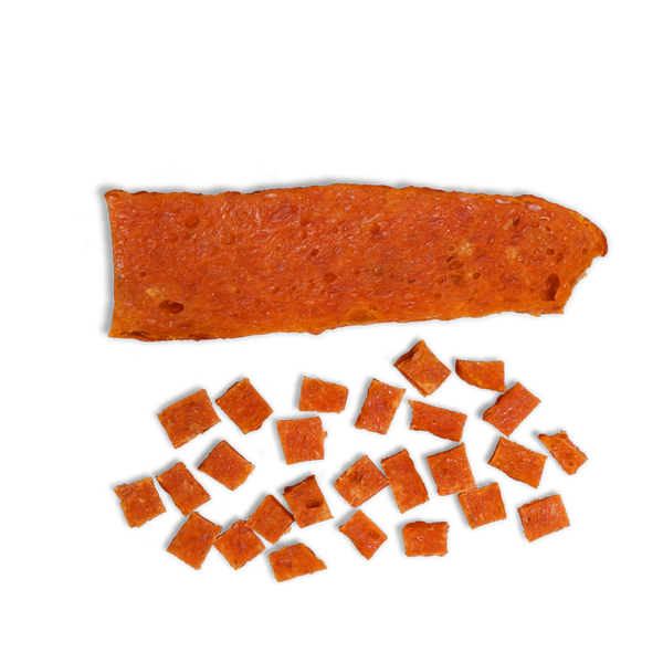 A rectangular sheet labeled "Chicken and Sweets" sits above several small, square pieces cut from it, resembling all-natural dog treats on a white background.
